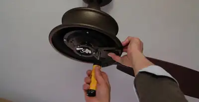 Electrician installing ceiling fan mounting bracket and fixture in Cambridge, MA