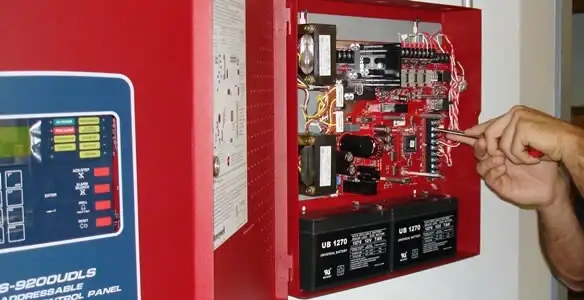 fire alarm installation service showing technician configuring fire alarm control panel in Cambridge, MA