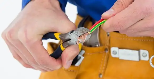 licensed electrician securing electrical wiring with professional tools during service work in Cambridge, MA