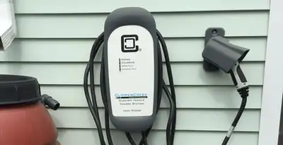 Outdoor electric vehicle charger installation on residential wall in Cambridge, MA